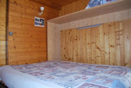 a bedroom with a bed in a wooden wall at Vieille Bergerie 6 in Le Fernuy