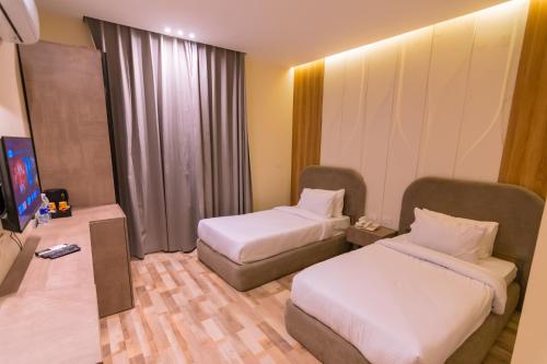 a hotel room with two beds and a television at Elevana Boutique hotel in Cairo