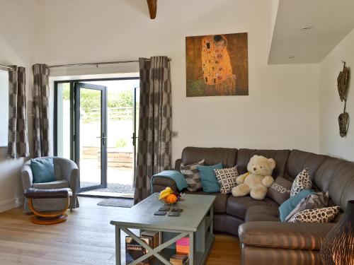 a living room with a couch and a teddy bear at Ty Isaf Cottage in Ffair-fâch
