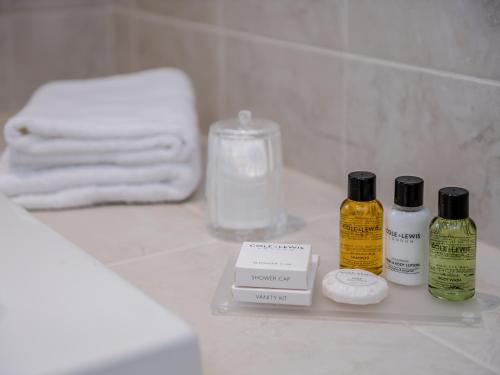 a bathroom with three bottles of soap and towels at Wisteria House in Henstead