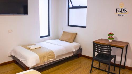 a bedroom with a bed and a desk with a chair at Fabis in Baños