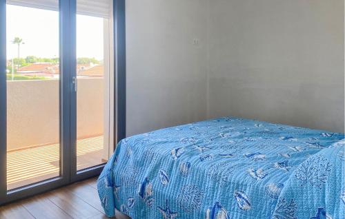 ein Schlafzimmer mit blauem Bett und Balkon in der Unterkunft 4 Bedroom Awesome Apartment In Kaukana in Marina di Ragusa