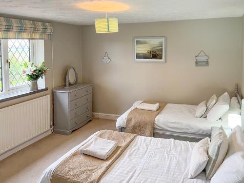 a bedroom with two beds and a window at Ash Cottage E1224 in Winthorpe