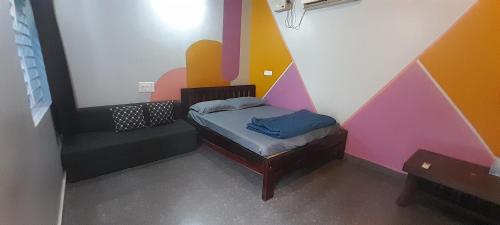 a bedroom with a bed with a colorful wall at Gokarna Beach Near Homestay RV in Gokarna