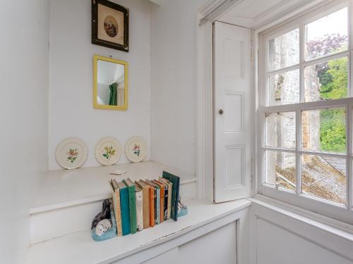a shelf of books on a window sill in a room at The Ivy Wing in Slickly