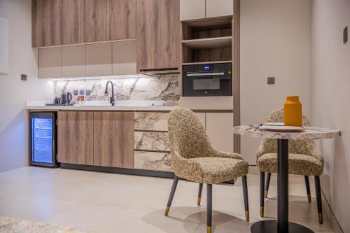 a kitchen with a table and two chairs and a sink at Liora ليورا in Riyadh