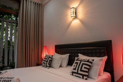 a bedroom with a bed with pillows and a light on the wall at COLOMBO Water Front in Boralesgamuwa