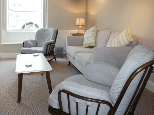 a living room with a couch and two chairs at Anchor Cottage in Deal