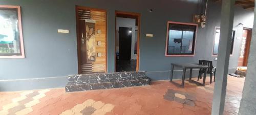 a room with a table and a door and a table and chairs at Gokarna Beach Near Homestay RV in Gokarna