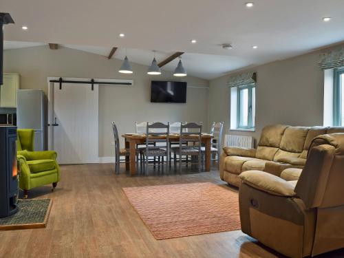 a living room with a couch and a table at Wagtail Cottage in Foxton