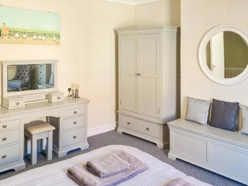 a bedroom with a desk and a mirror at Filey House in Sheringham