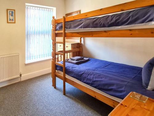 a bedroom with two bunk beds and a window at Filey House in Sheringham