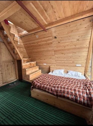 a bedroom with a bed in a wooden room at Skytouch cottage stargazing in Jibhi
