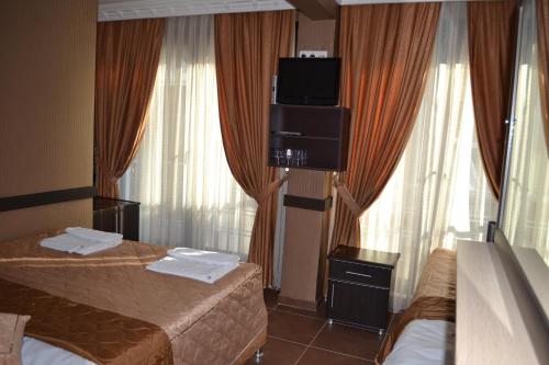 a hotel room with two beds and a flat screen tv at Ares Hotel in Istanbul