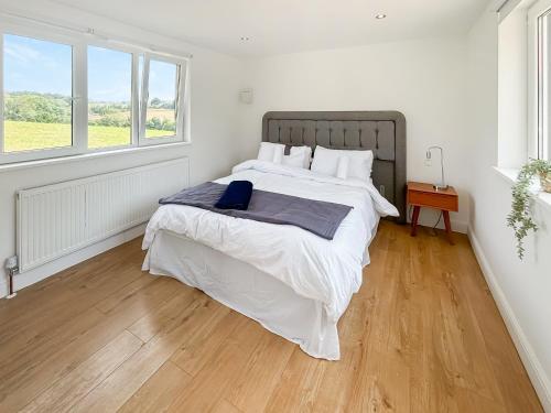 a bedroom with a large bed with a wooden floor at The Stables - Uk47819 in Merstham