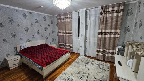 a bedroom with a bed with a red blanket at Нур-Ордо in Pokrovka