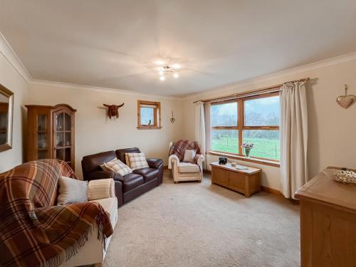 un soggiorno con divano, sedie e finestra di Shellhill Cottage a Kirkcudbright