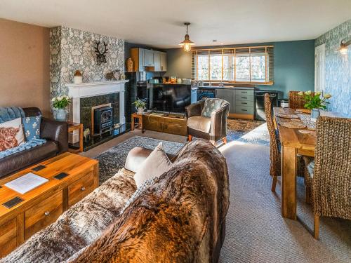 a living room with a couch and a table at Garden Cottage in Tain