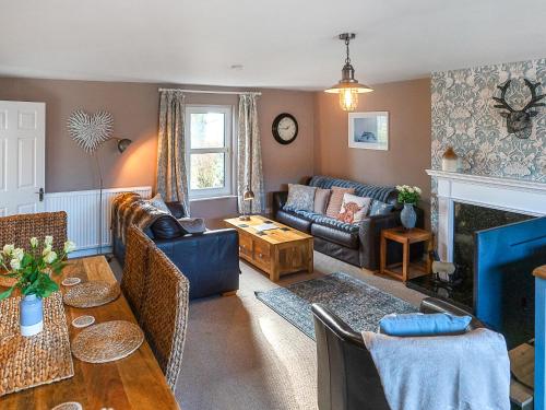 a living room with a couch and a fireplace at Garden Cottage in Tain