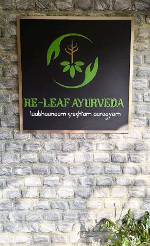 a sign on the side of a brick wall at Re-Leaf Hom-Treat Homestay in Wayanad
