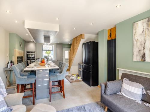 a kitchen and living room with a table and chairs at Squirrel Cottage in Glossop