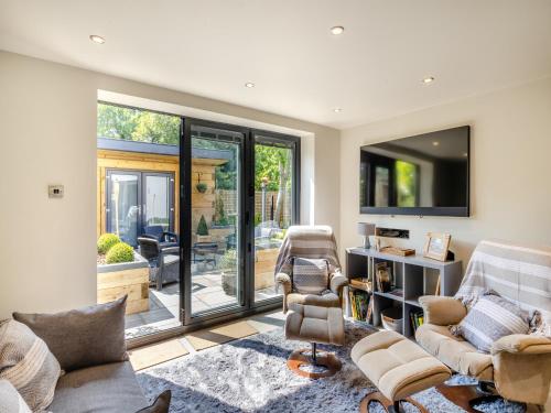 a living room with a sliding glass door at Squirrel Cottage in Glossop