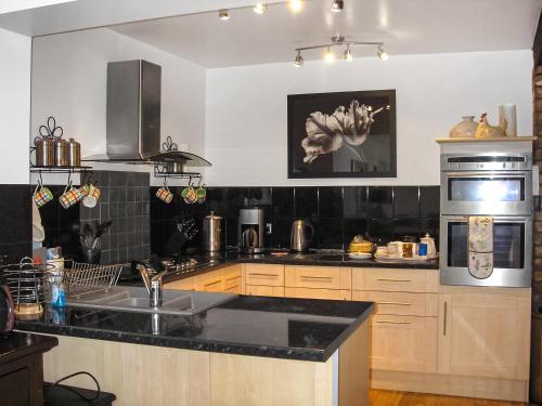 a kitchen with a sink and a stove top oven at Holly-Garth in Helmsley