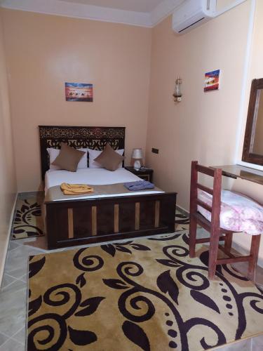 un dormitorio con una cama y una silla en Desert Dream Apartment, en Merzouga