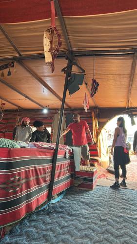 eine Gruppe von Personen, die unter einem Zelt stehen in der Unterkunft Sands of time desert camp in Aqaba