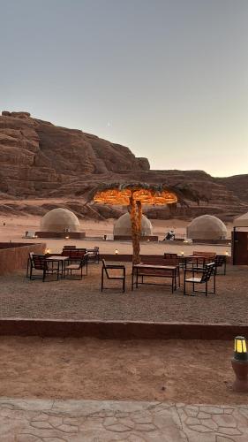 eine Gruppe von Bänken und Tischen in der Wüste in der Unterkunft Sands of time desert camp in Aqaba