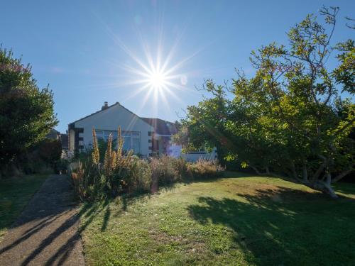 un jardín con el sol en el cielo en Greenridge, en Totland