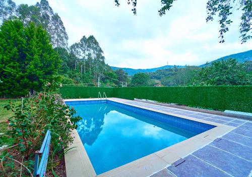 a swimming pool with blue water in a yard at Ministers Mansion Kanthalloor Pool Resort by VOYE HOMES in Kanthalloor