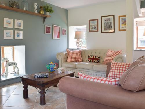 un salon avec un canapé et une table dans l'établissement Mill Cottage, à Llanybri
