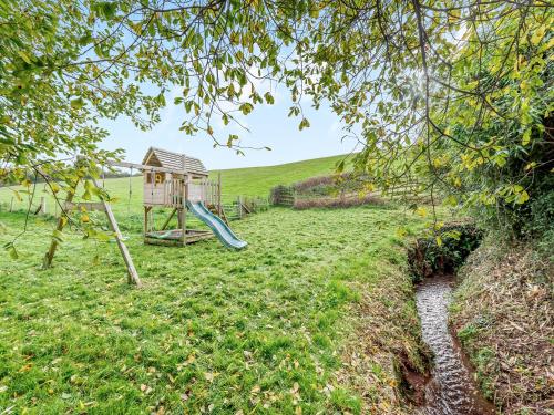 a playground with a slide and a play house at Hollacombe Lodge in Colebrooke