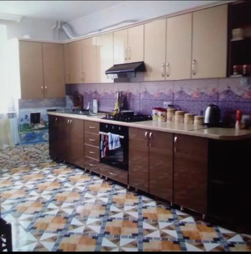 a kitchen with a stove and a tile floor at Guesthouse Amiran Tabatskuri in Tabatsquri