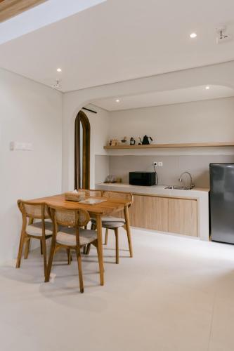 a kitchen and dining room with a wooden table and chairs at The Bora Villas in Ngaglik