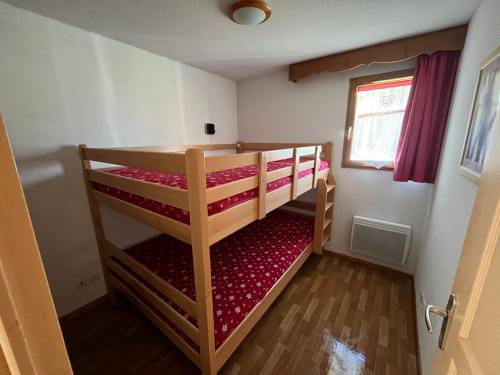 two bunk beds in a small room with a window at Appartement 4-6 personnes à Puy-Saint-Vincent in Puy-Saint-Vincent