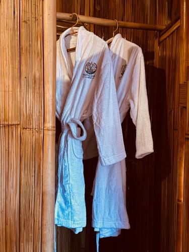 a group of white shirts hanging on a rack at Green Lander Ubud in Ubud
