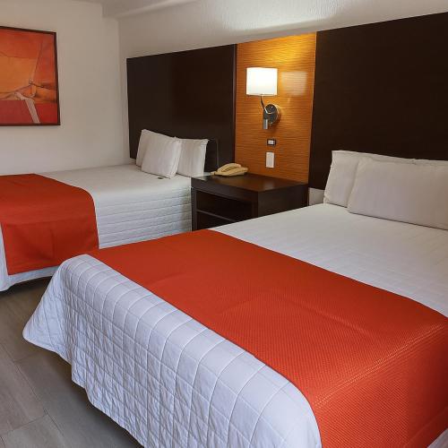 a hotel room with two beds and a telephone at Paris FC Hotel in Poza Rica de Hidalgo