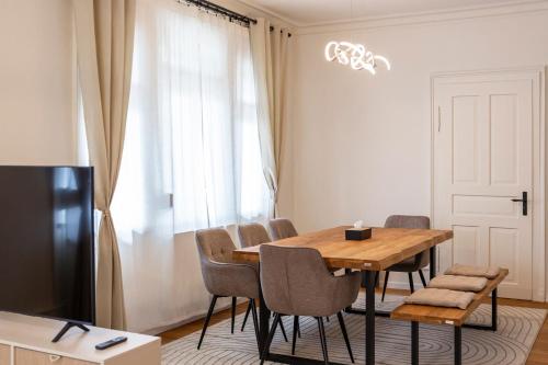a dining room with a wooden table and chairs at Ruhestein Quartier - Charaktervolle Wohnung perfekt für Gruppen&Familien, ideale Lage, nahe Bhf, bestens geeignet für entspannte als auch akitve Aufenthalte in malerischer Umgebung in Baiersbronn