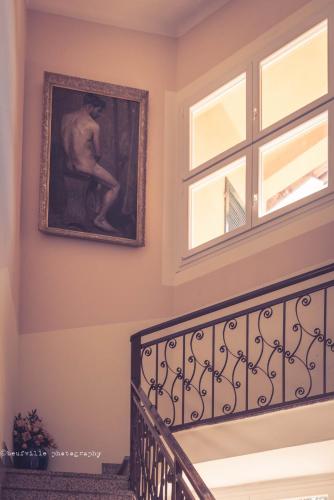 a painting of a man sitting on a chair next to a window at Park Hotel Salice Terme - OltrePò Pavese - in Salice Terme