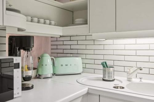 a kitchen with a counter top with a sink at Aaacentralriversidepenthousewbalcony&waterview in Zürich