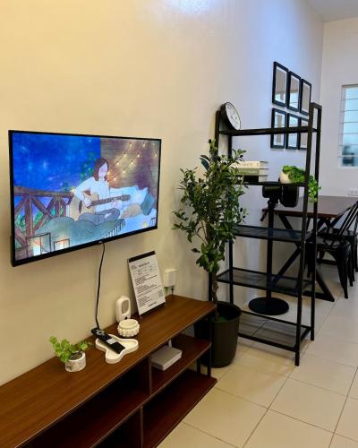 a living room with a flat screen tv on the wall at Cozy 2 Bedroom Home in Lucena with AC and Fast WiFi in Ilayang Dupay