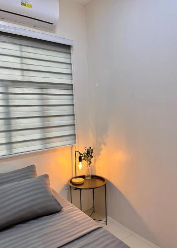 a bedroom with a bed and a table with a lamp at Cozy 2 Bedroom Home in Lucena with AC and Fast WiFi in Ilayang Dupay