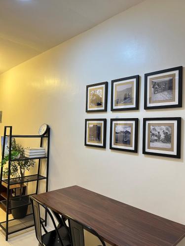 a dining room with a table and four pictures on the wall at Cozy 2 Bedroom Home in Lucena with AC and Fast WiFi in Ilayang Dupay