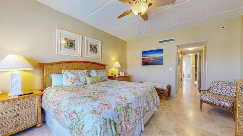 Un dormitorio con una cama grande y una silla. en Pier Point Ocean View Unit D-52, en St. Augustine Beach
