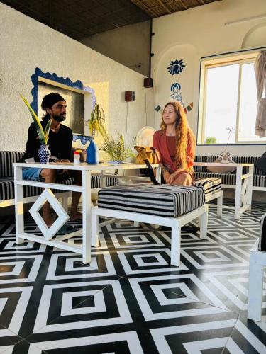 a woman sitting on a bench in a room at Hariom Tatsat Retreat in Pushkar