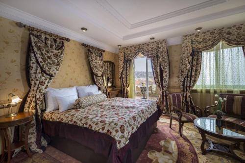 a bedroom with a bed with curtains and a table at Erla Villa Boutique Hotel in Eger