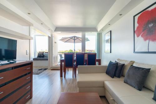 a living room with a couch and a table with an umbrella at Modern 2 Bedroom Apartment with Balcony in Cascais in Cascais