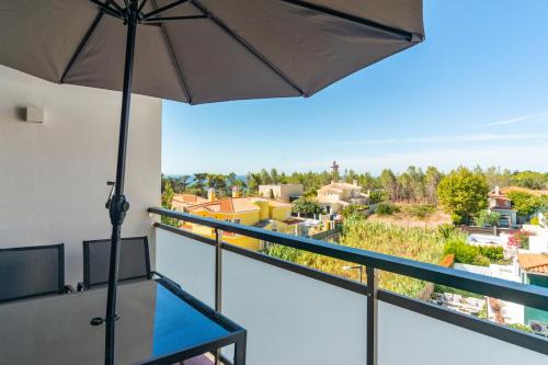 a balcony with an umbrella and a view at Modern 2 Bedroom Apartment with Balcony in Cascais in Cascais